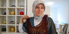 Foto: Gabriele Meister Nesrin Kaya hält sich ein braunes Strickkleid an